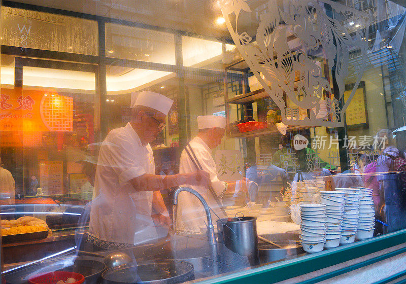 香港著名馄饨面馆“Mai En”的临街橱窗展示了厨师们的烹饪过程。